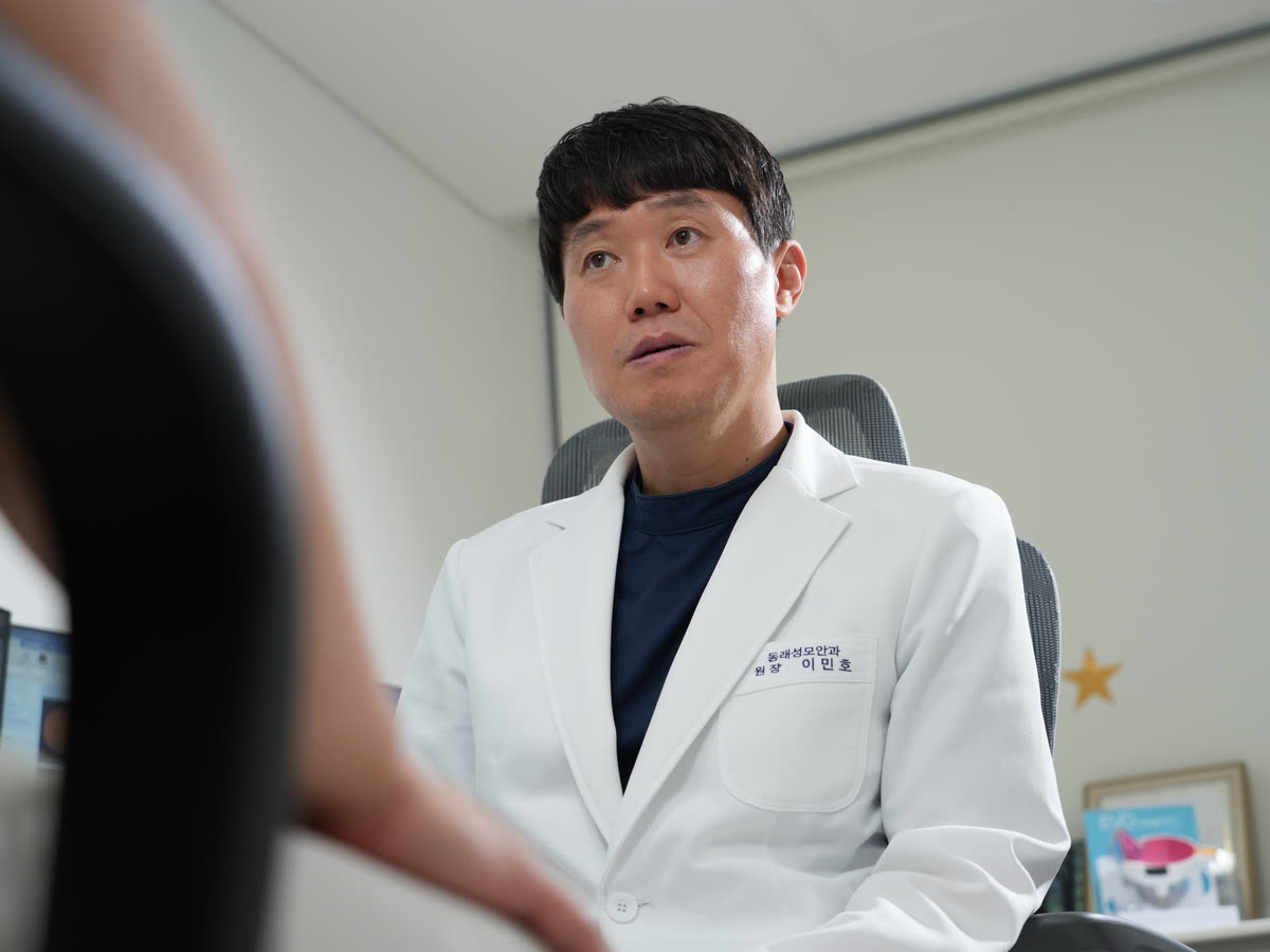 진료실에서 이민호 대표원장이 환자와 마주 앉아 이야기하고 있습니다.